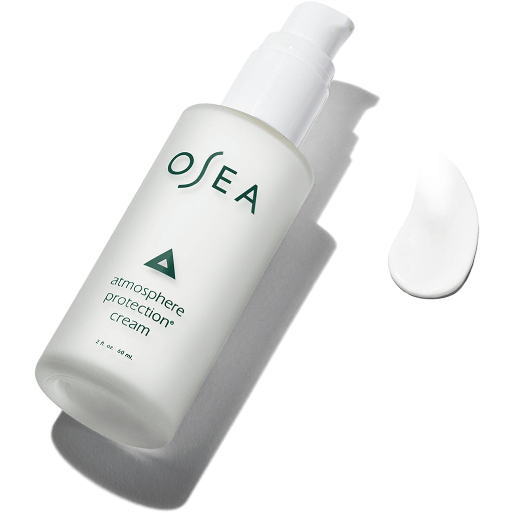 A bottle of osea atmosphere protection cream alongside a sample dollop of the product on a clean white surface.