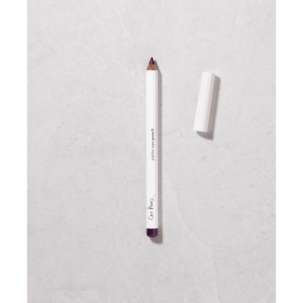 A white pencil with a purple tip lying next to an eraser on a textured surface.
