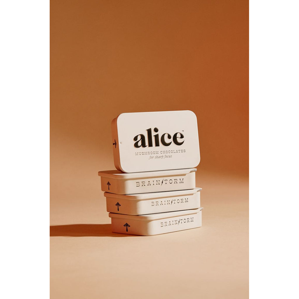 Stack of three metal tins with "alice" and "brainform" branding on a beige background.