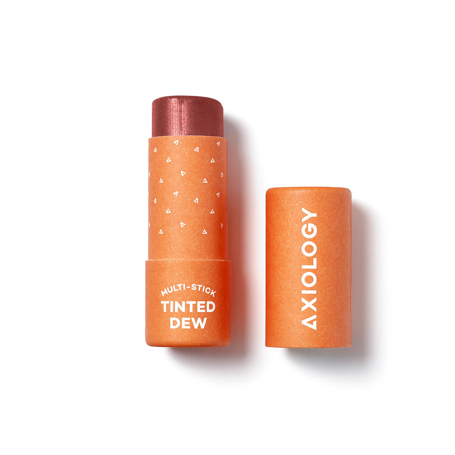 Axiology brand multi-stick in tinted dew shade with the cap removed, isolated on a white background.