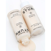 Two bottles of st. ives body lotion lying side by side with one of them squeezed open, dispensing a dollop of cream.