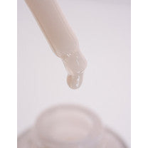 Liquid droplet suspended from a pipette above a container.