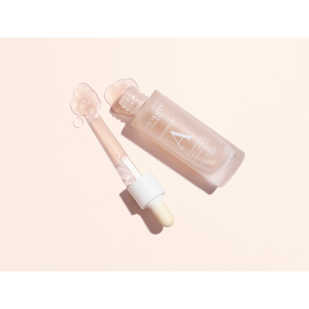 Cosmetic serum bottle with dropper on a pastel background.