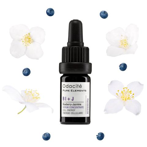 A bottle of odacite bl+j blueberry-jasmine serum concentrate surrounded by jasmine and white flowers with blueberries.