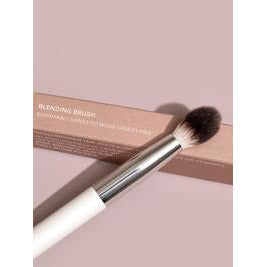 A blending brush against a pink background with its packaging labeled "blending brush.