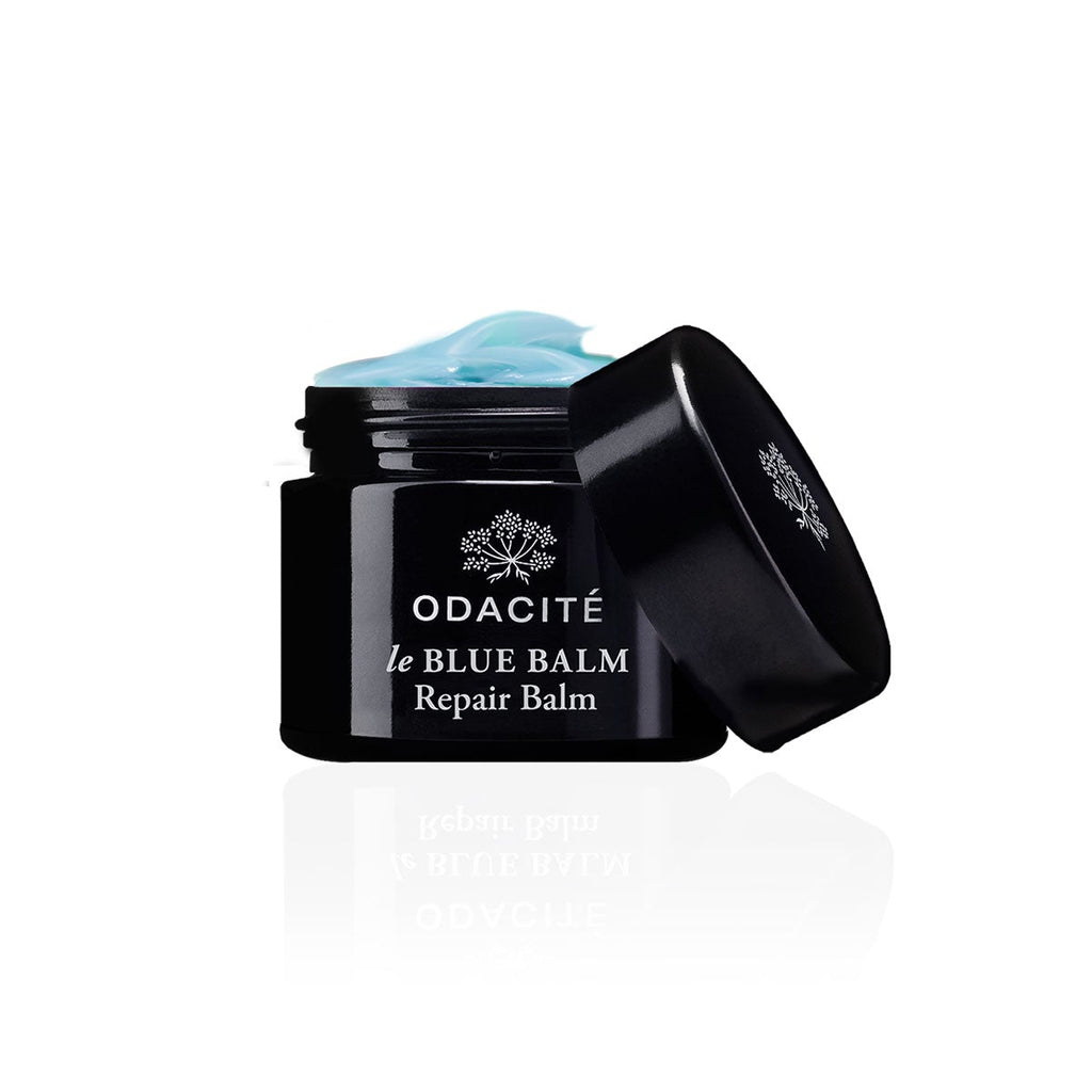 Jar of odacite le blue balm repair balm with open lid and product visible.