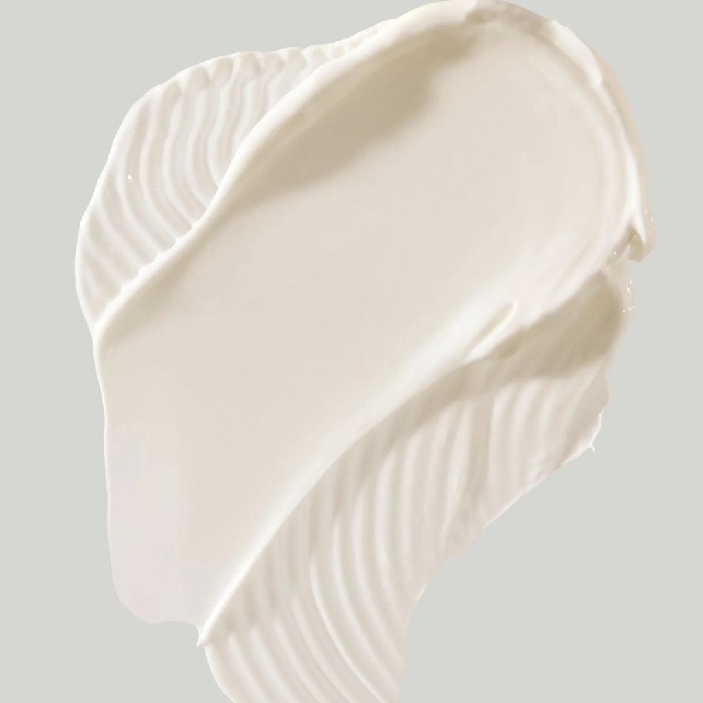 A dollop of creamy white substance with a smooth, whipped texture against a pale background.