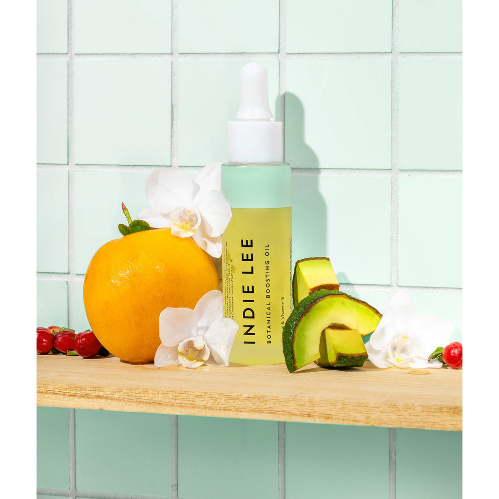 Cosmetic serum bottle with natural ingredients displayed on a shelf.