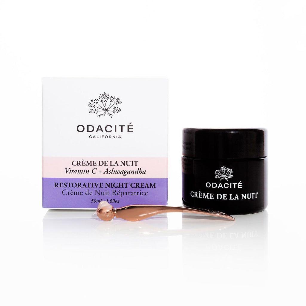 A jar of odacite restorative night cream with its packaging and a small spatula.