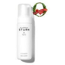 White bottle of dr. barbara sturm cleanser with a festive decoration at the top right corner.