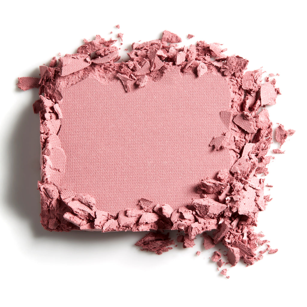 Compact powder makeup with a crumbled texture around the edges on a white background.