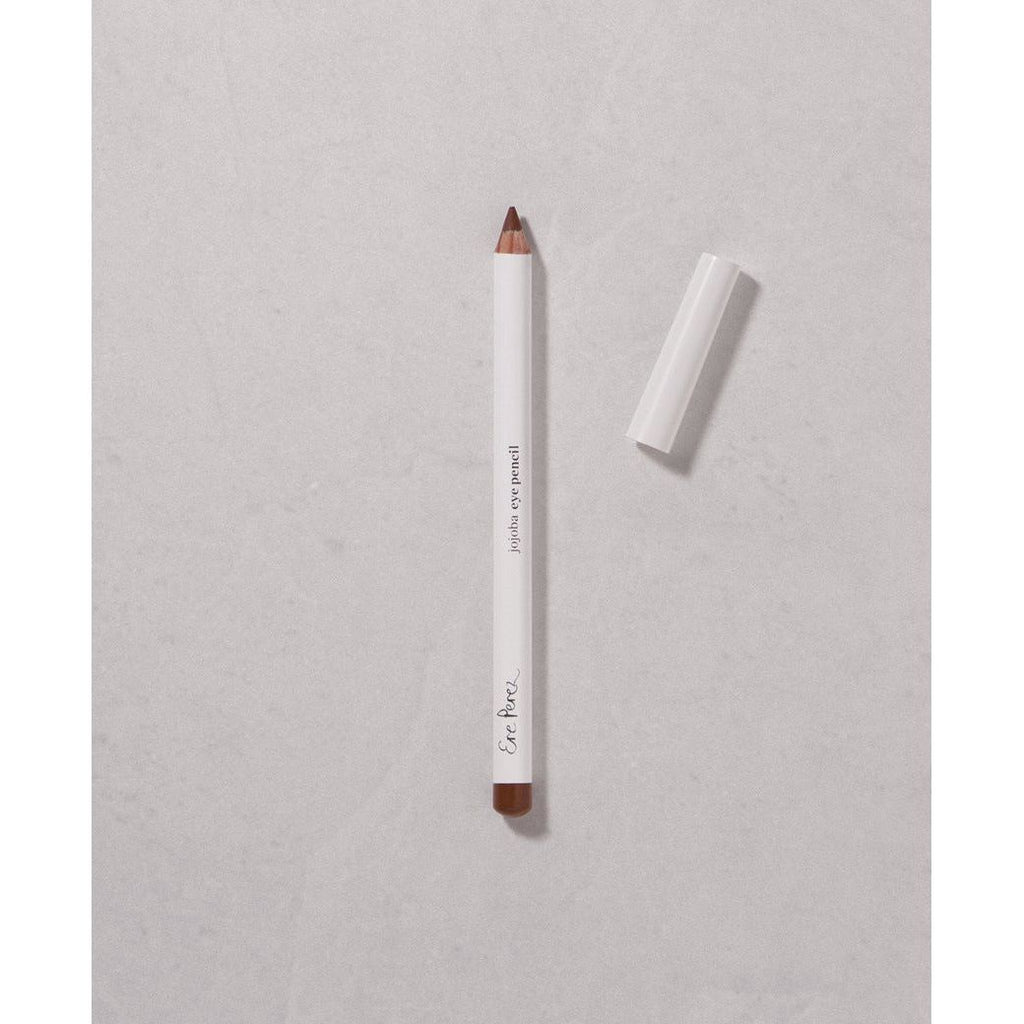 White eye pencil with cap off on a textured surface.