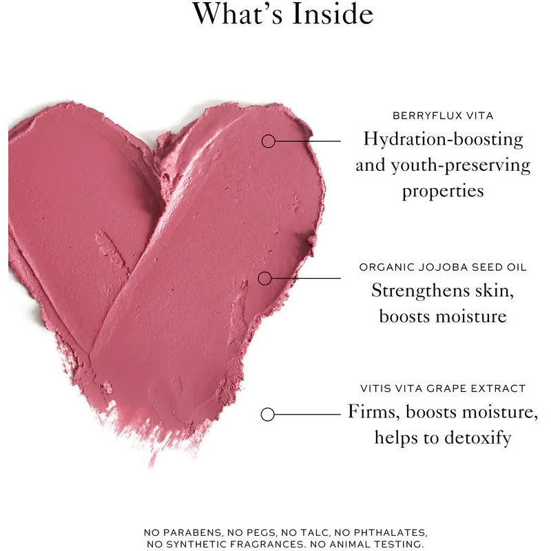 A swatch of pink cosmetic cream in the shape of a heart, with annotations highlighting its key ingredients and claims of being free from parabens, pegs, talc, phthalates.