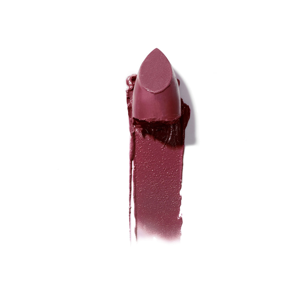 A smear of dark mauve lipstick beside the lipstick tube on a white background.