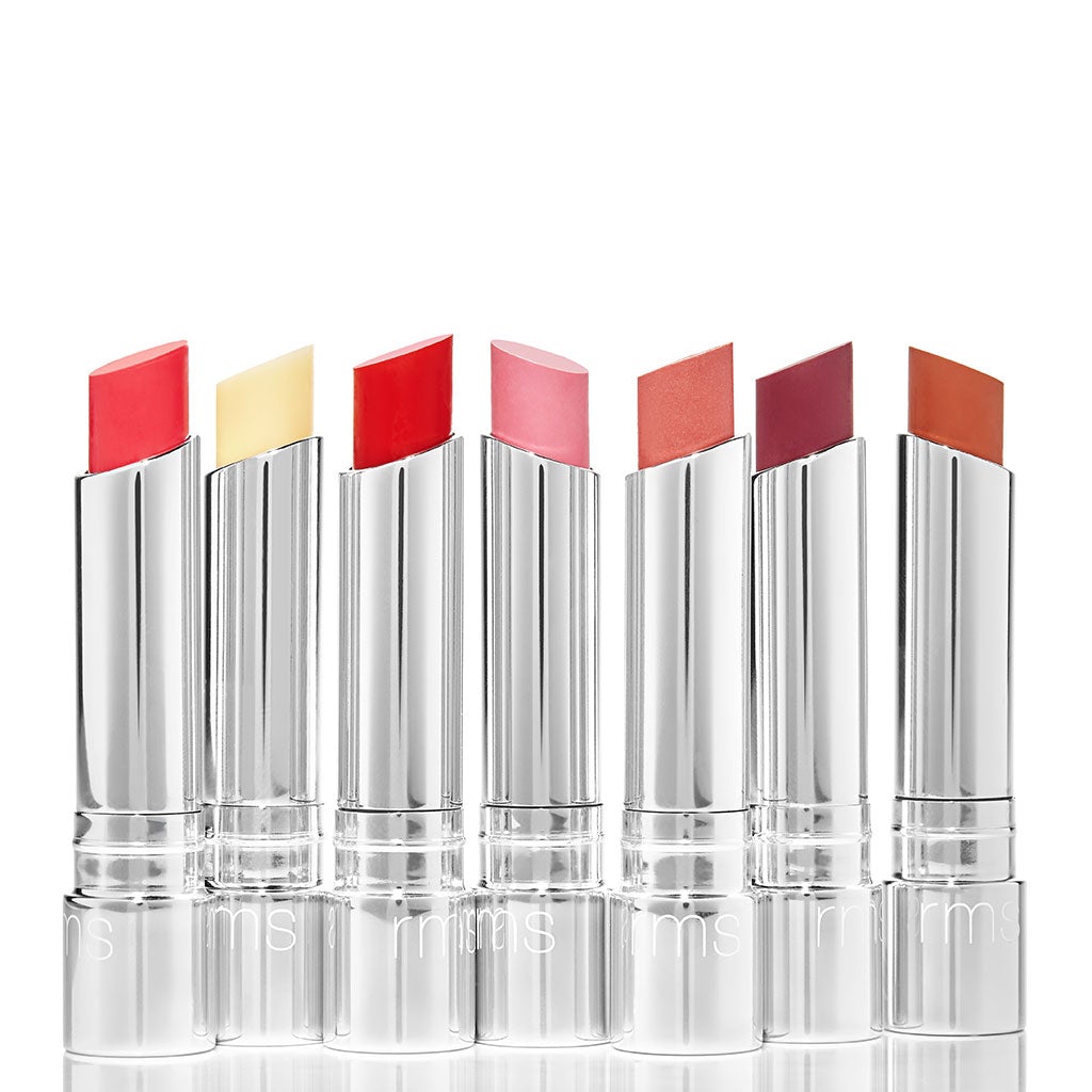 A collection of six variously colored lipsticks with silver cases arranged in a row against a white background.