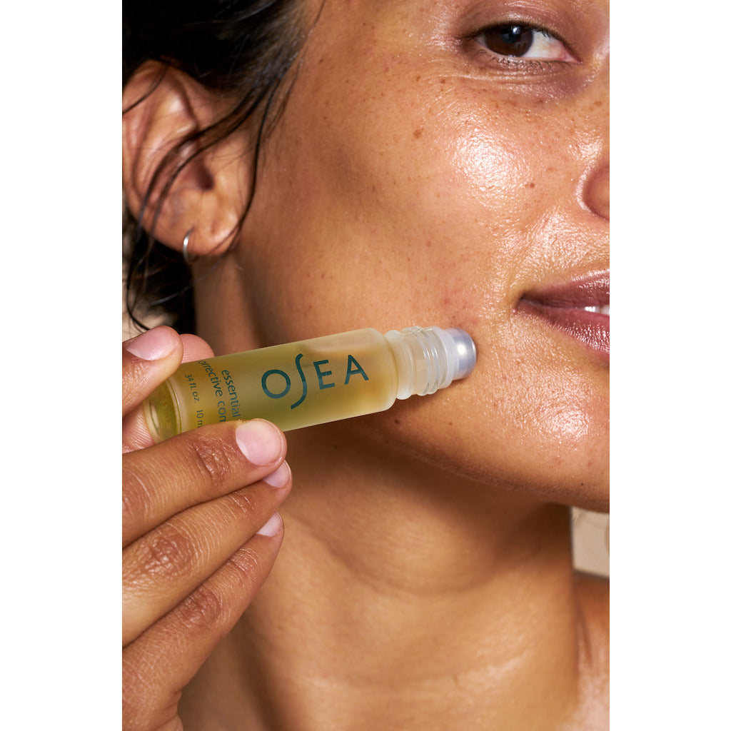 Woman applying skincare product to her cheek.
