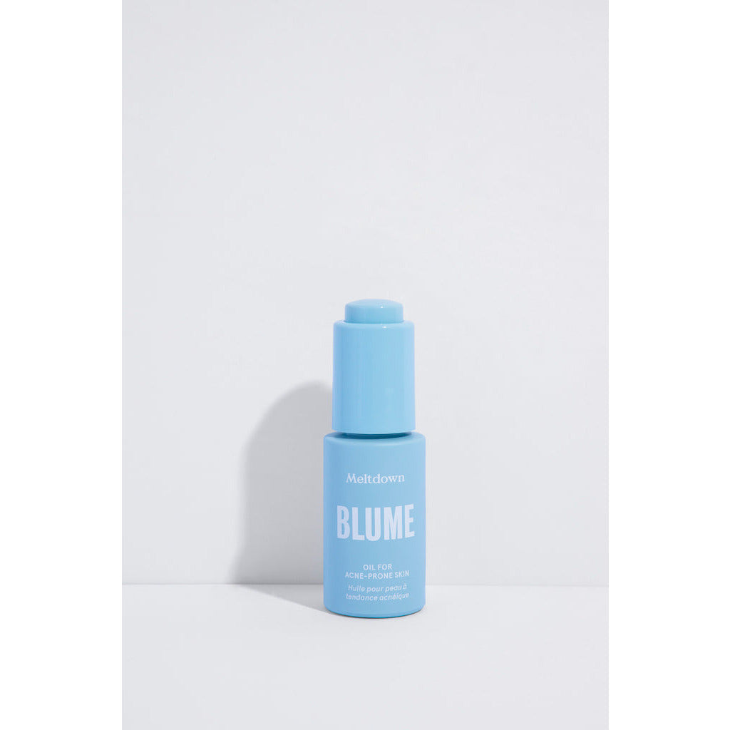 A blue bottle of blume meltdown acne treatment oil against a white background.