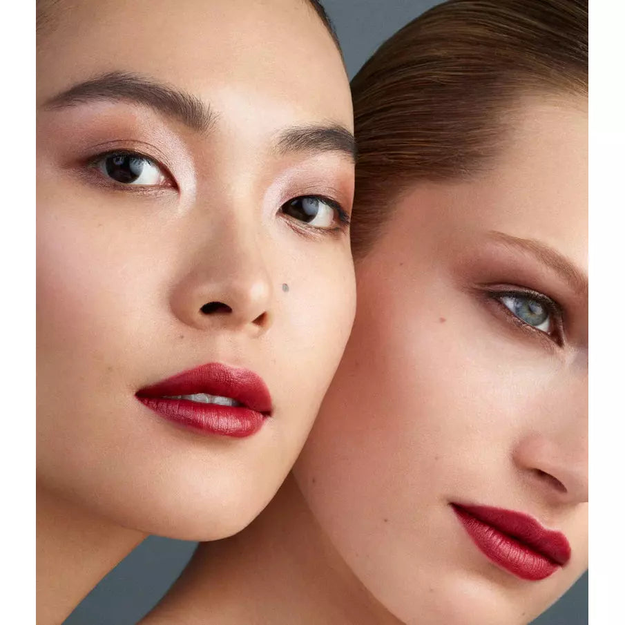 Two women with bold red lipstick showcasing a close-up of their makeup.