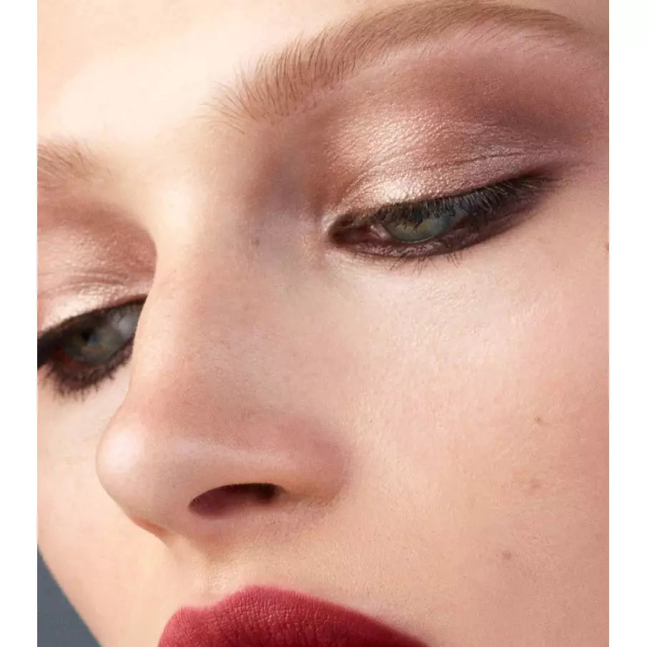 Close-up of a person with subtle eye makeup and bold red lipstick.