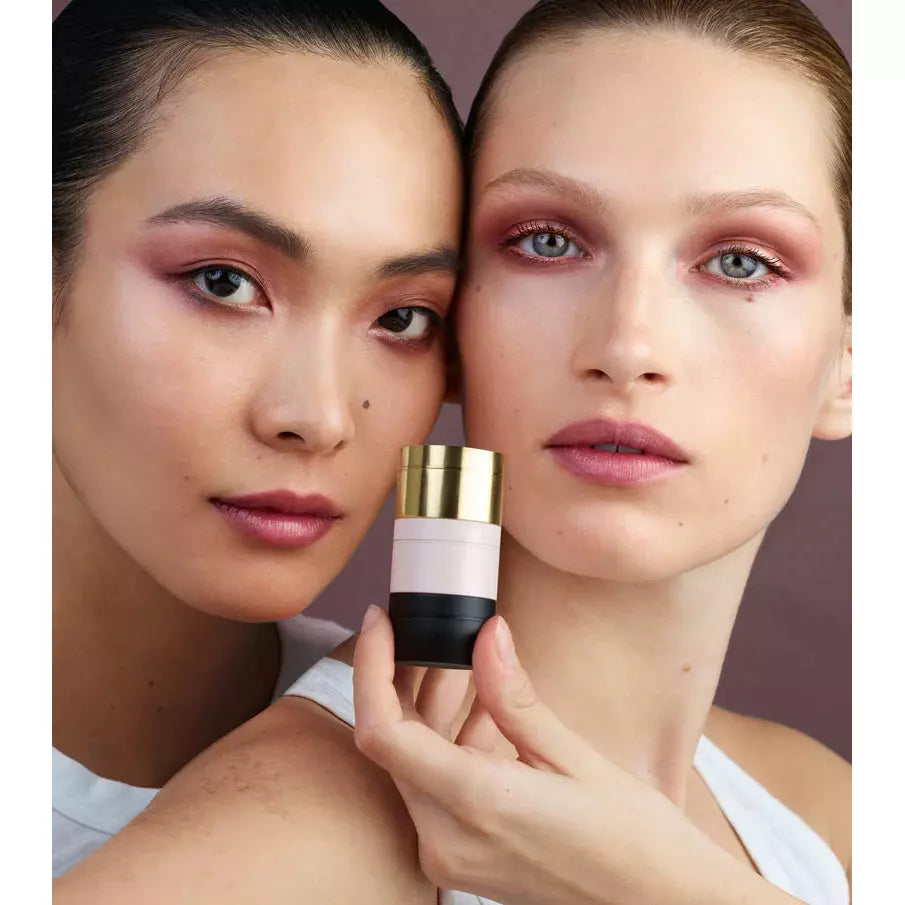 Two women with makeup showcasing a cosmetic product.