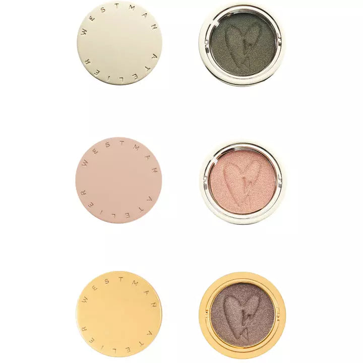 Four circular cosmetic compacts showcasing different shades of eyeshadow.