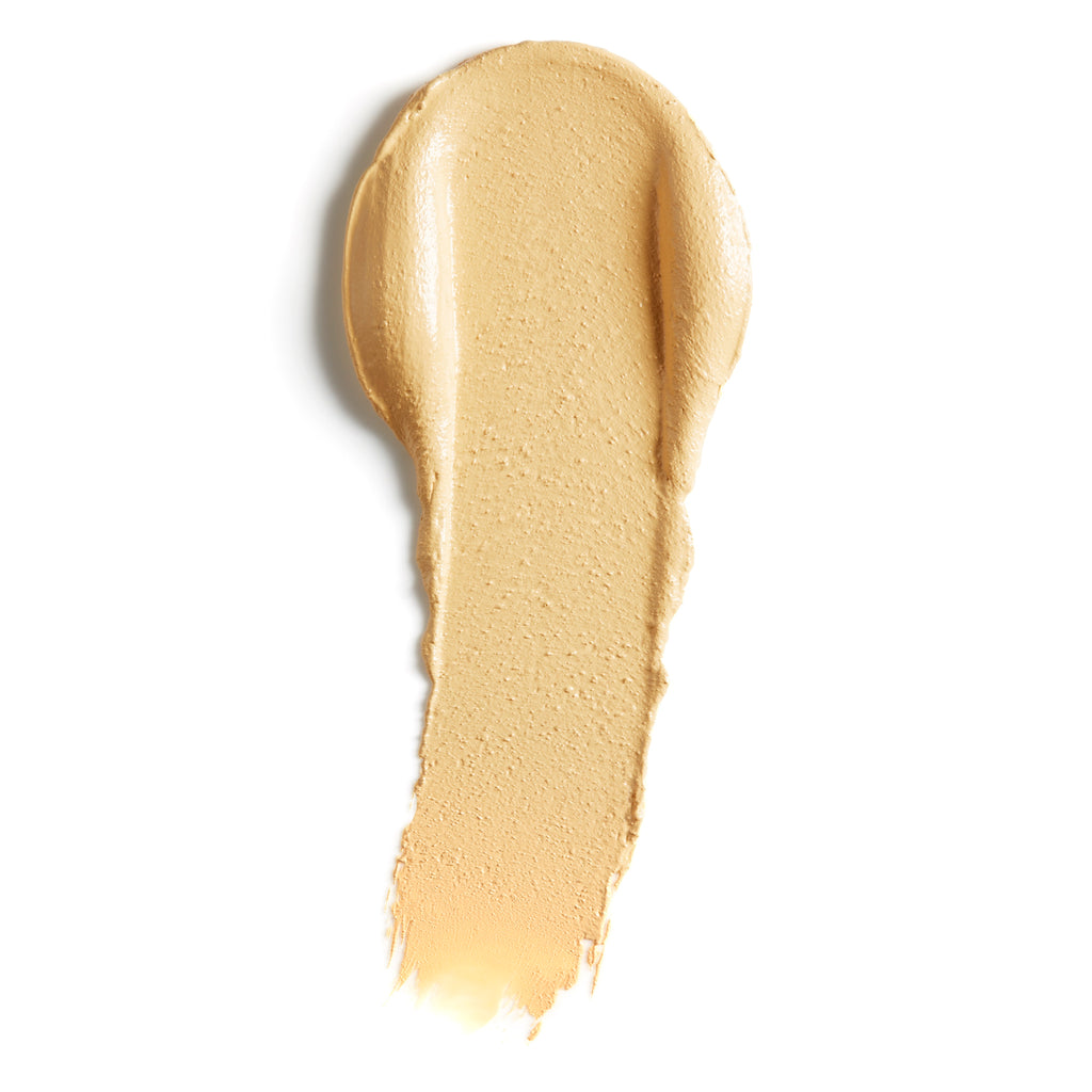 A stroke of creamy liquid foundation makeup on a white background.