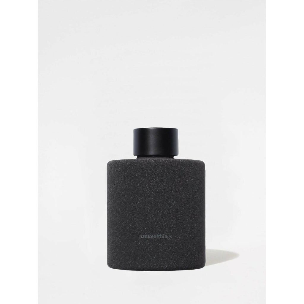 A matte black bottle with a minimalist design labeled "natureofthings".