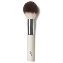 A makeup brush with a beige handle and black bristles.