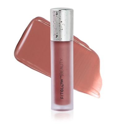 A tube of fitglow beauty lip gloss with a translucent cap, displayed against a tilted matching color background.
