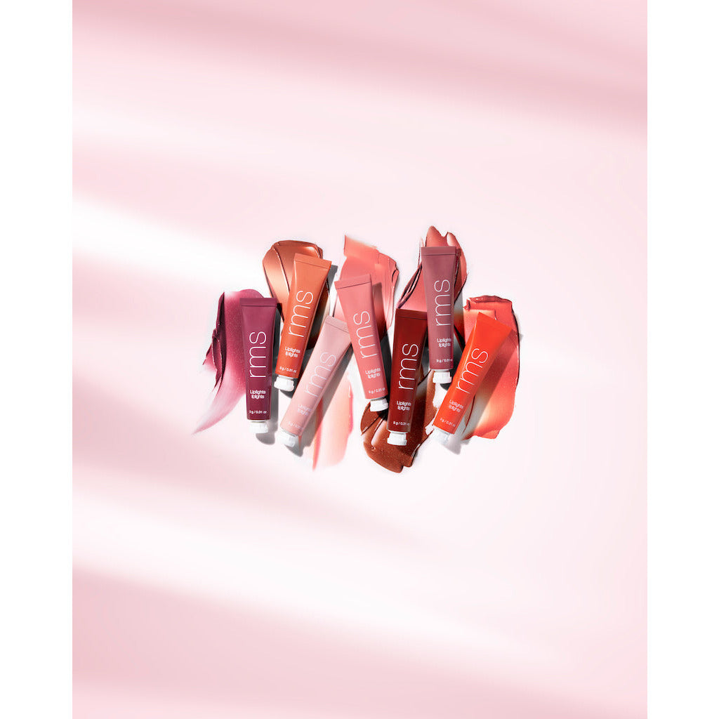 Various shades of lipstick tubes elegantly displayed on a pink background.
