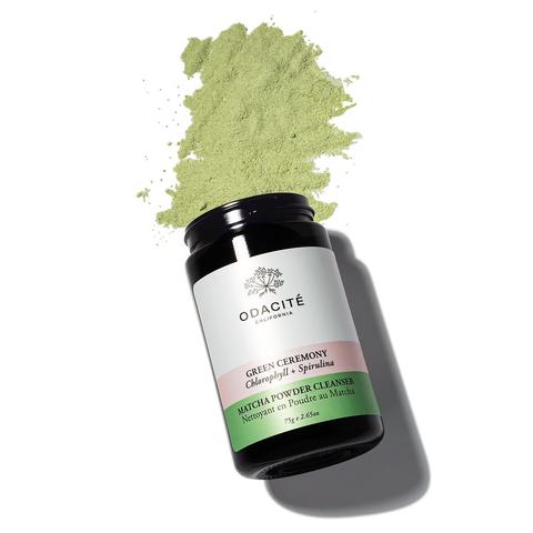 A jar of odacite green ceremony cleanser next to a spilled pile of green powder.