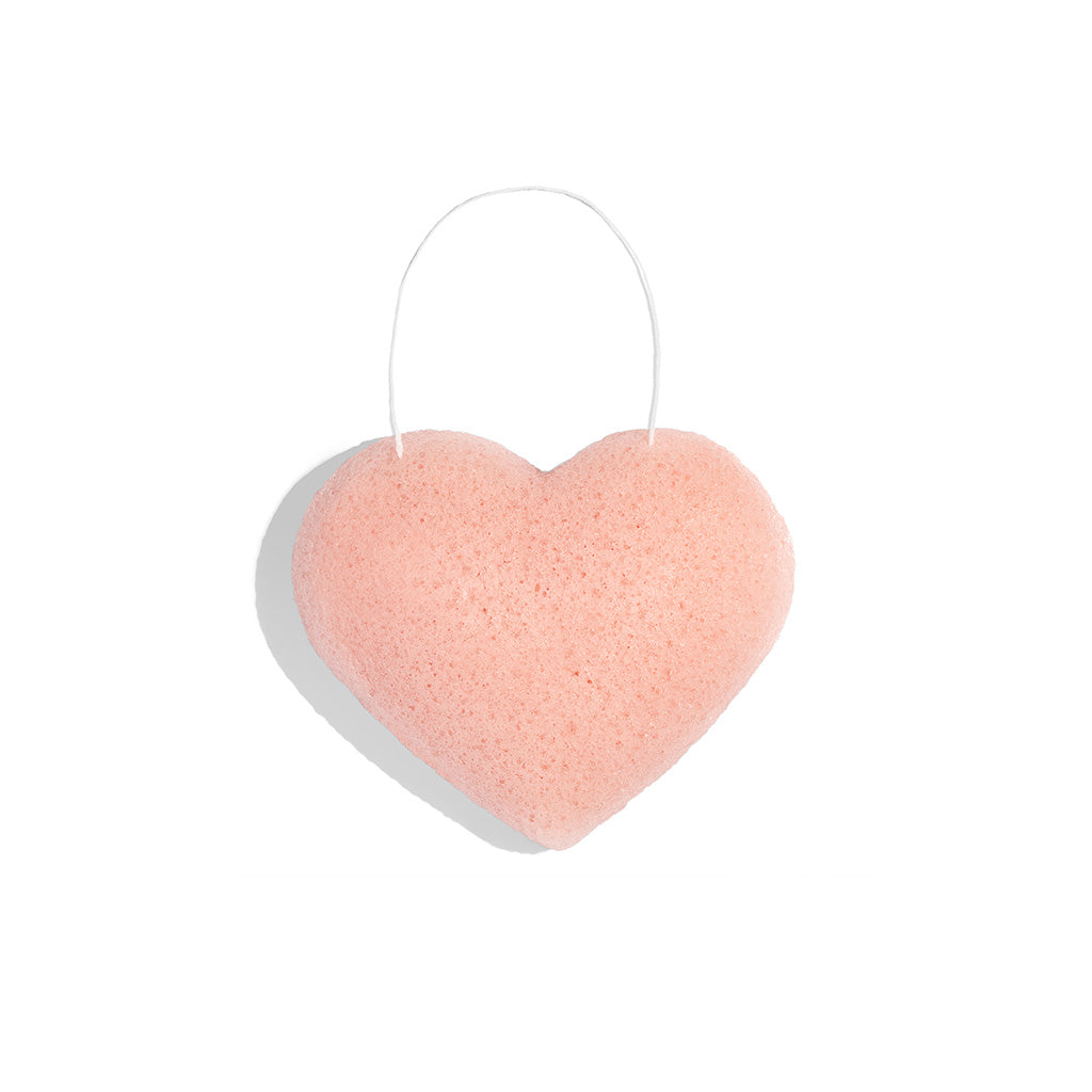 A heart-shaped pink bath bomb with a white base, isolated on a white background.