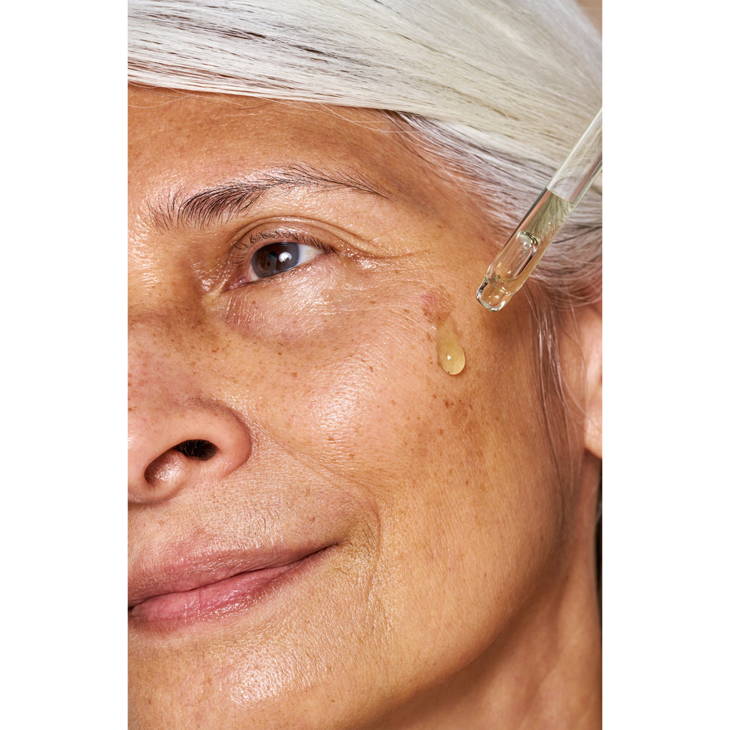 Application of serum to mature skin with a dropper.