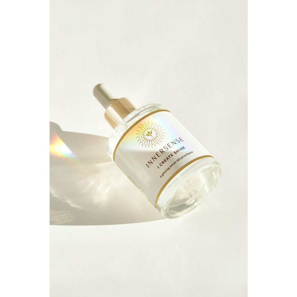 Cosmetic serum bottle with dropper in soft lighting.