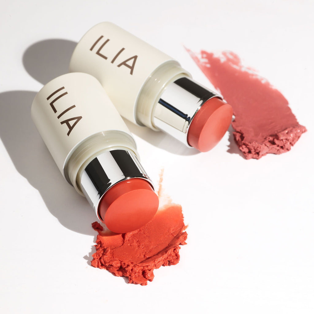 Two tubes of ilia blush with smudged product samples in front of each.