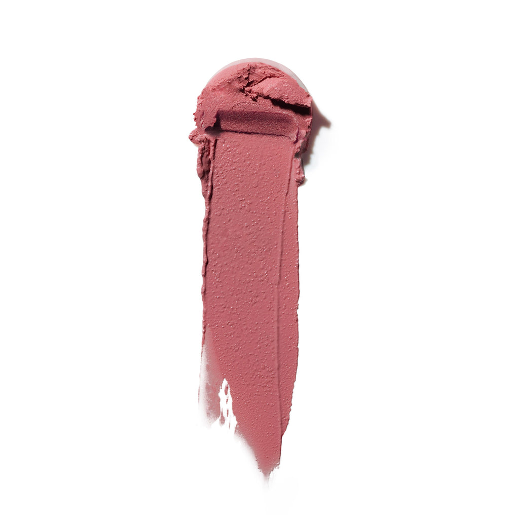 A swatch of creamy lipstick in a rose shade smeared against a white background.