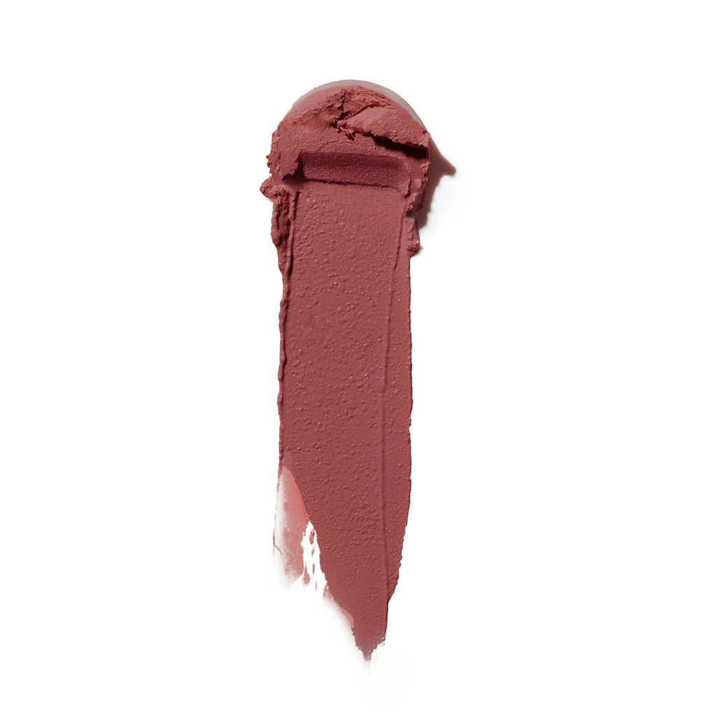 A swatch of matte lipstick in a deep rose shade smeared against a white background.