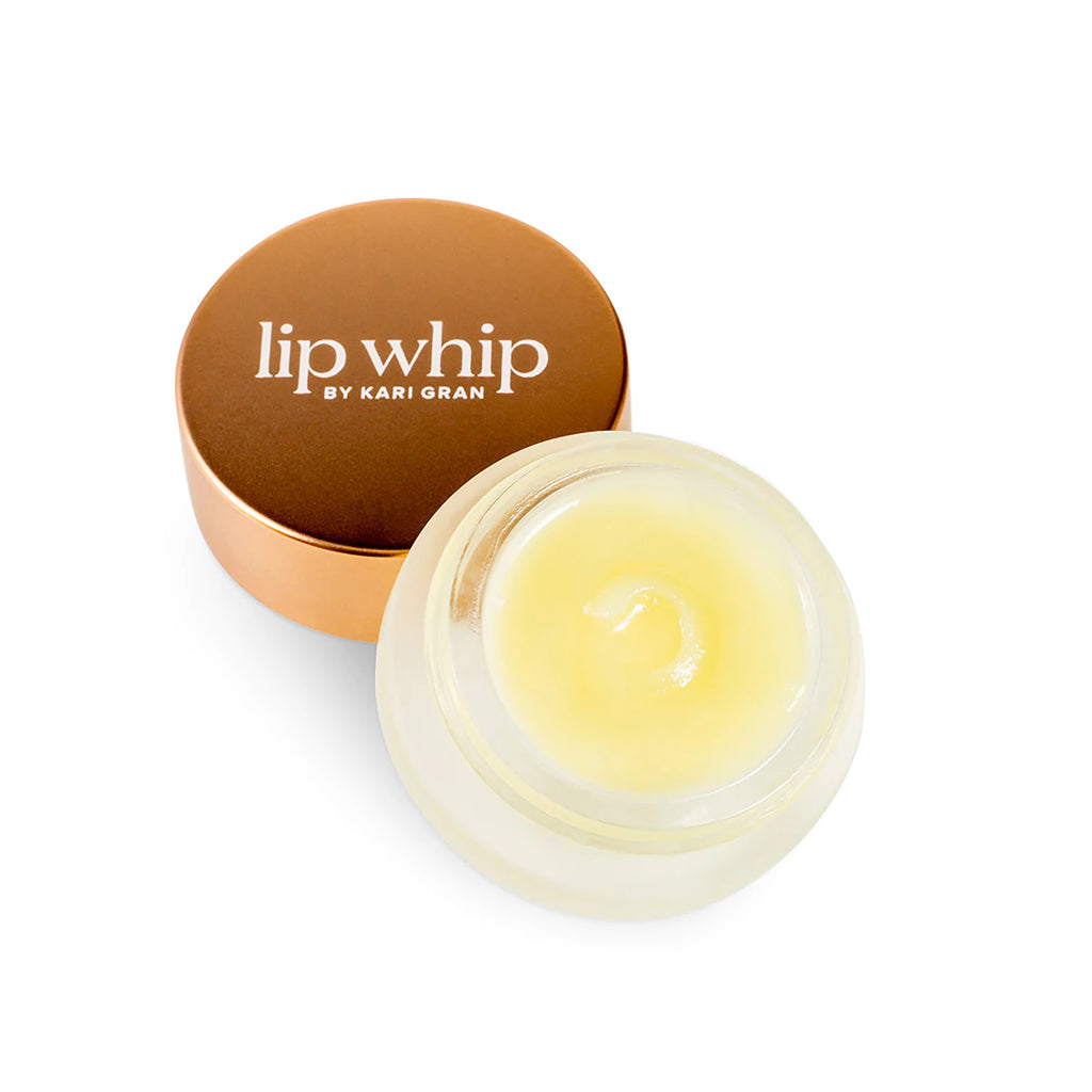 A jar of lip whip balm with its lid beside it on a white background.
