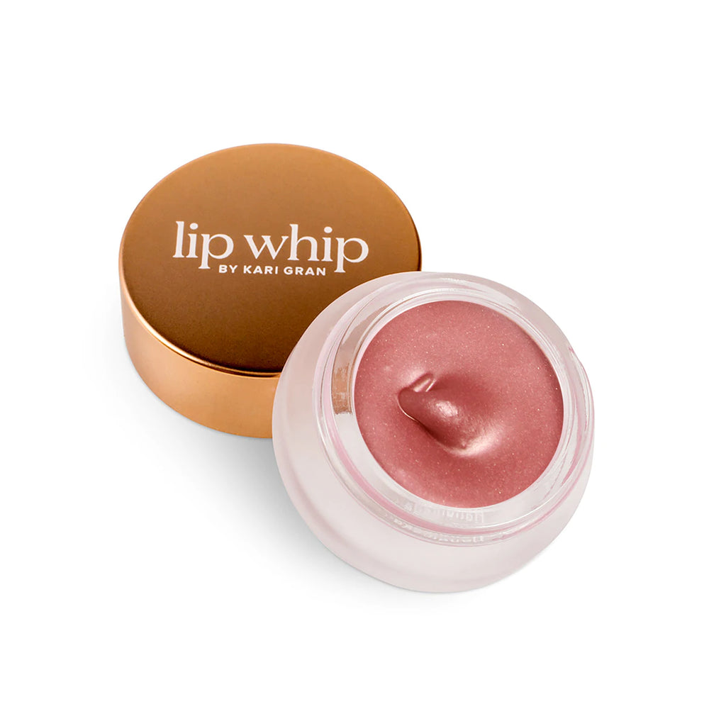 A jar of pink lip whip with its golden lid placed beside it on a white background.