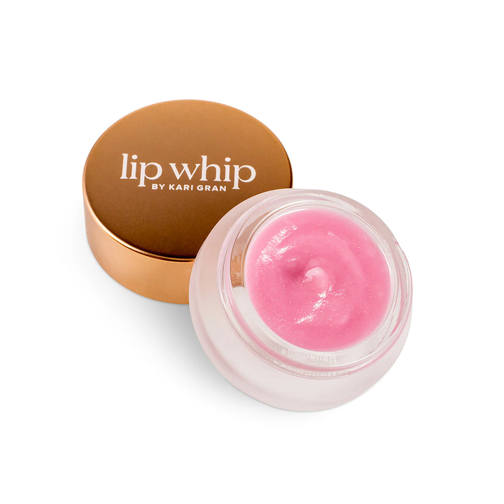 A jar of pink lip balm with its golden lid placed behind it.