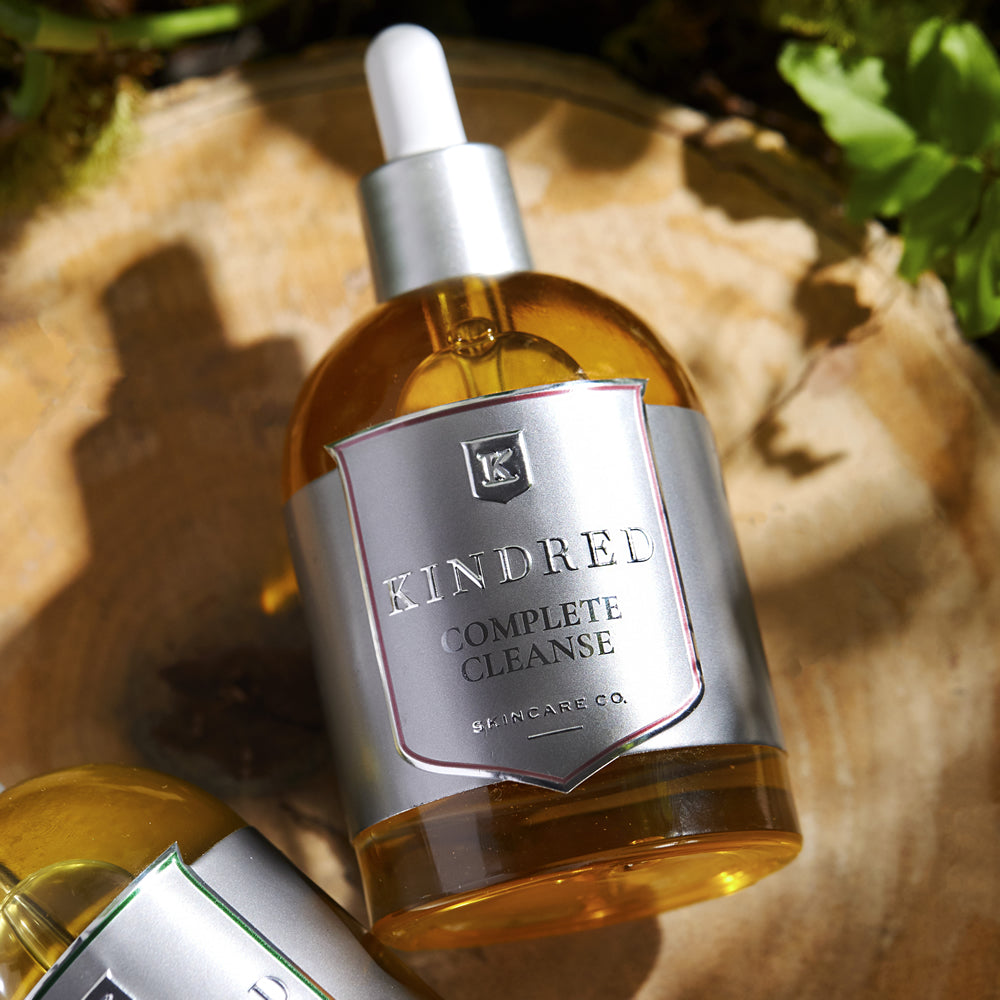 A bottle of kindred complete cleanse skincare oil on a natural background.