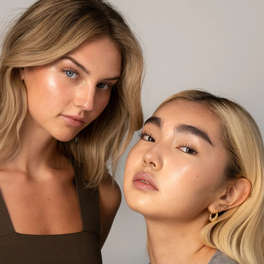 Two women with natural makeup posing for a close-up portrait.