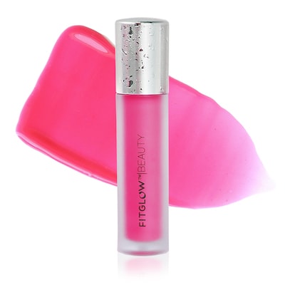 A pink lip gloss product with its cap leaning on its side against a white background.