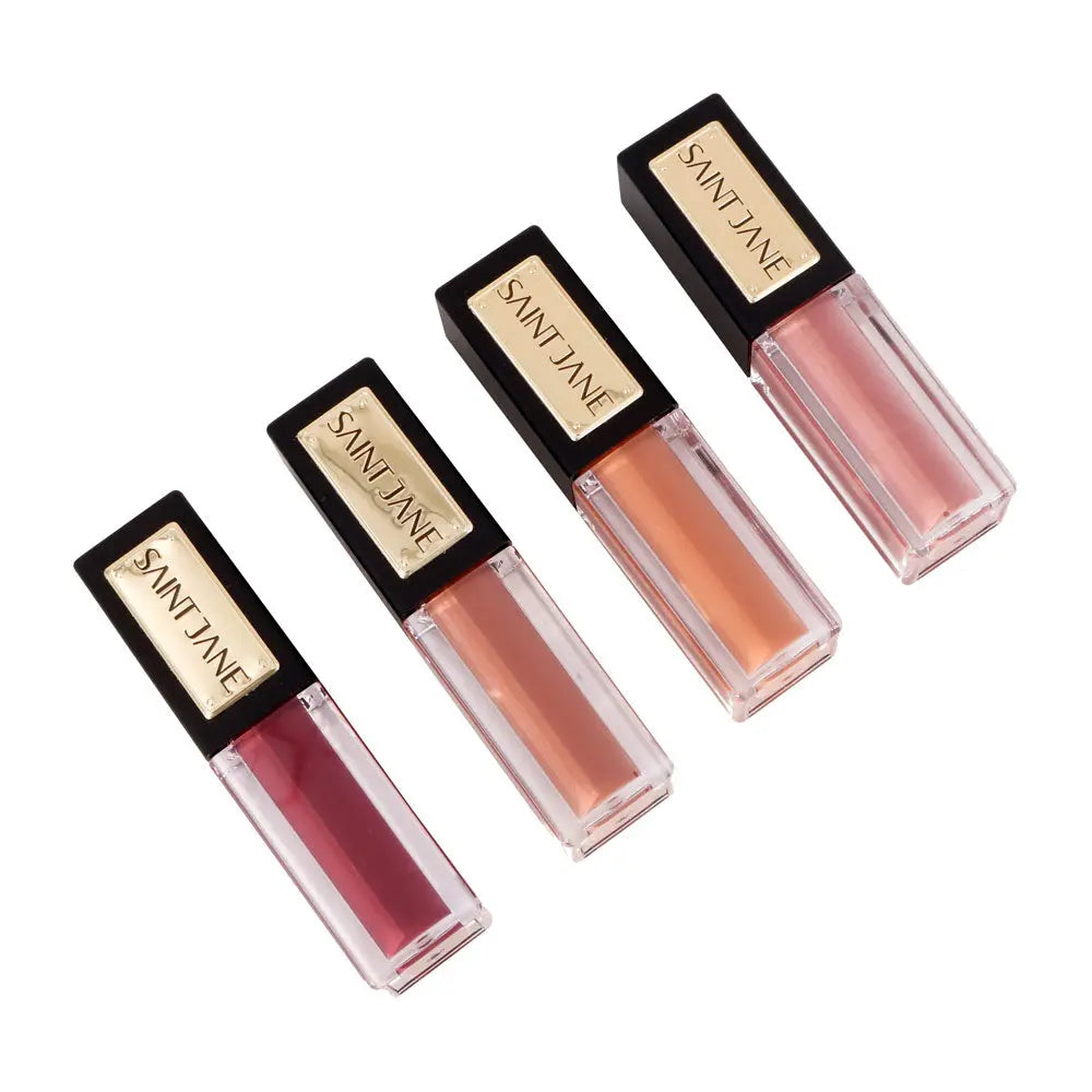 Four bottles of lip gloss in varying shades placed on a white background.