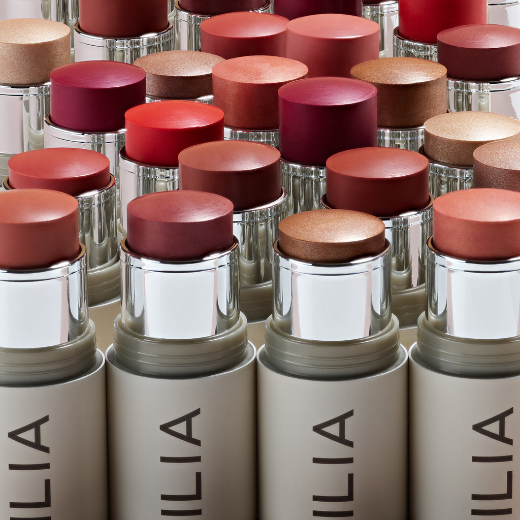 An array of cosmetic bottles with various shades of foundation.