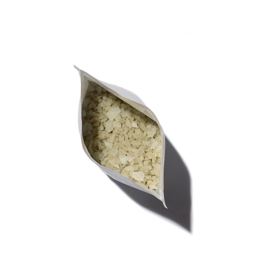 A bag of uncooked rice spilled open with contents visible against a white background.