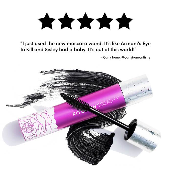 A mascara tube with a wand coated in black mascara lying next to a streak of the product, accompanied by a positive review quote.