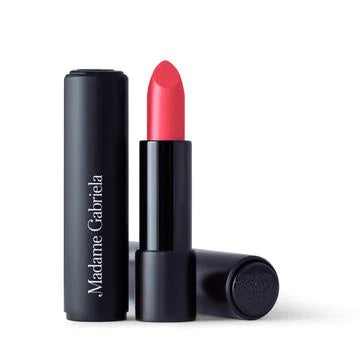 A tube of madame gabriela lipstick with the cap off, revealing a bright red lipstick against a white background.