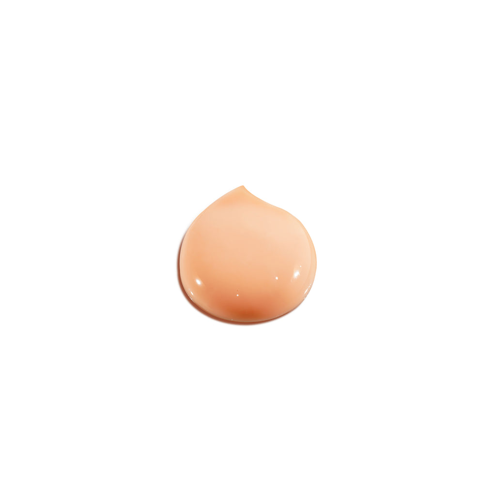 A single drop of foundation makeup against a white background.