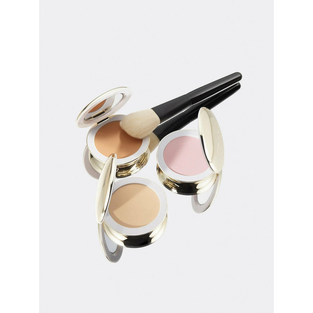 Compact makeup powders with mirror lids and a makeup brush on a white background.